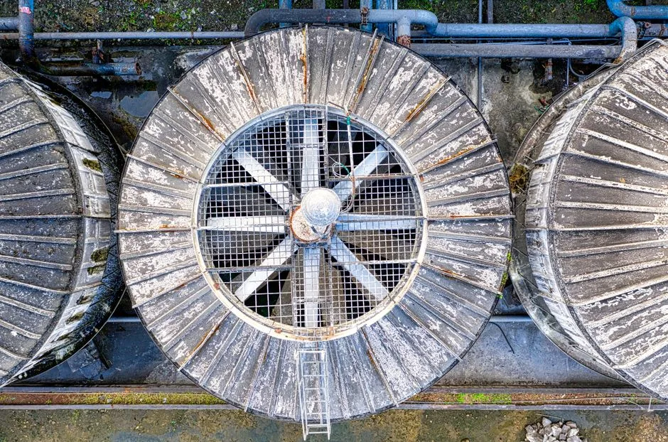 Low-angle view of industrial ventilation pipes and exhaust fans on a commercial rooftop