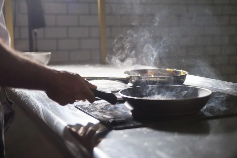 Steam rising in commercial kitchen showing why exhaust fan cleaning matters